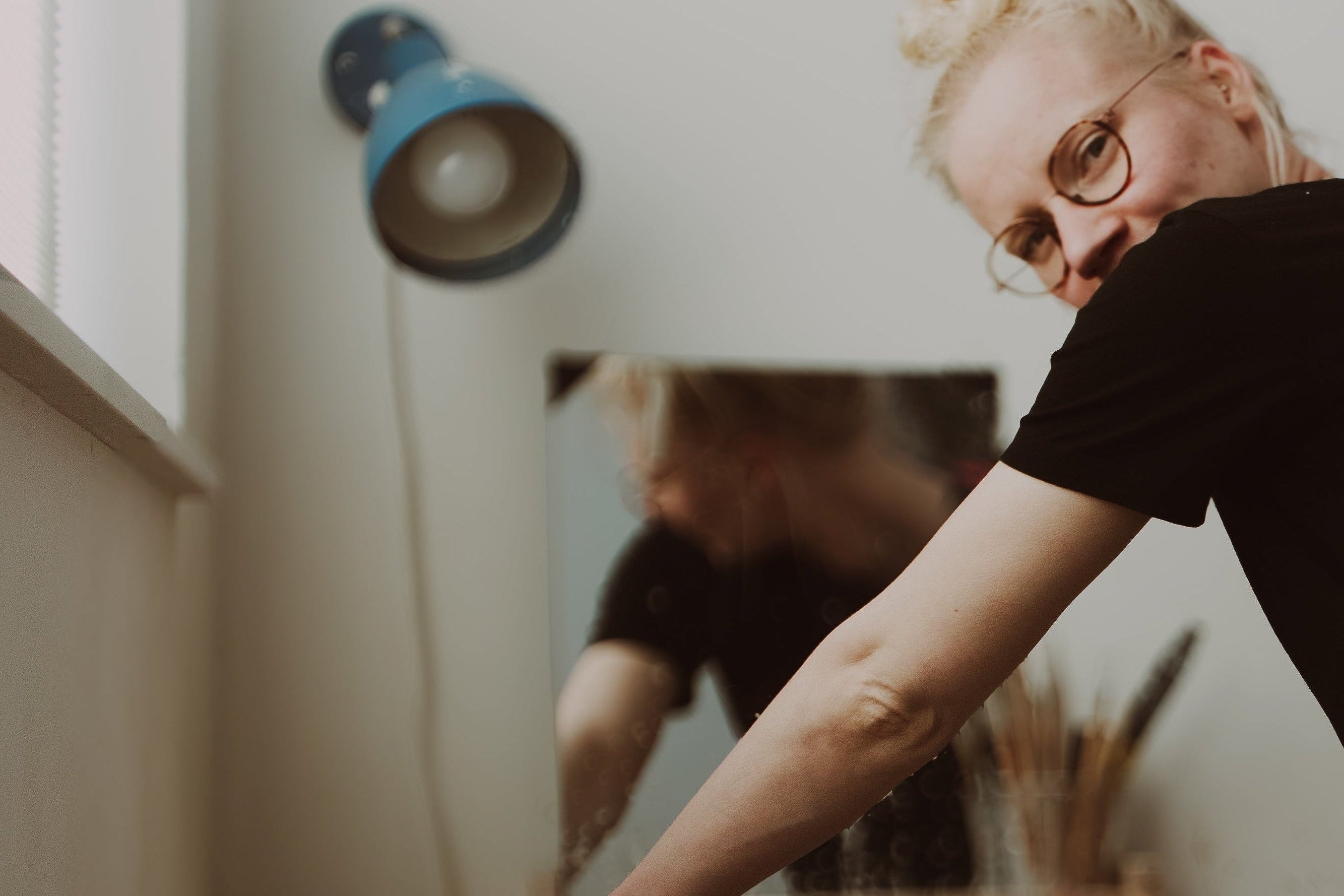 studio portrait of Marjolein at the pottery wheel, captured mid-process as she turns back from the wheel.